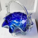 Blue glass basket with clear handle and white edge