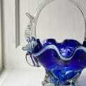 Blue glass basket with clear handle and white edge