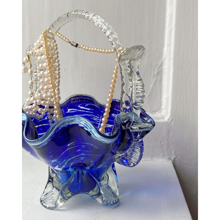 Blue glass basket with clear handle and white edge