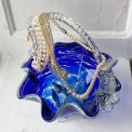 Blue glass basket with clear handle and white edge