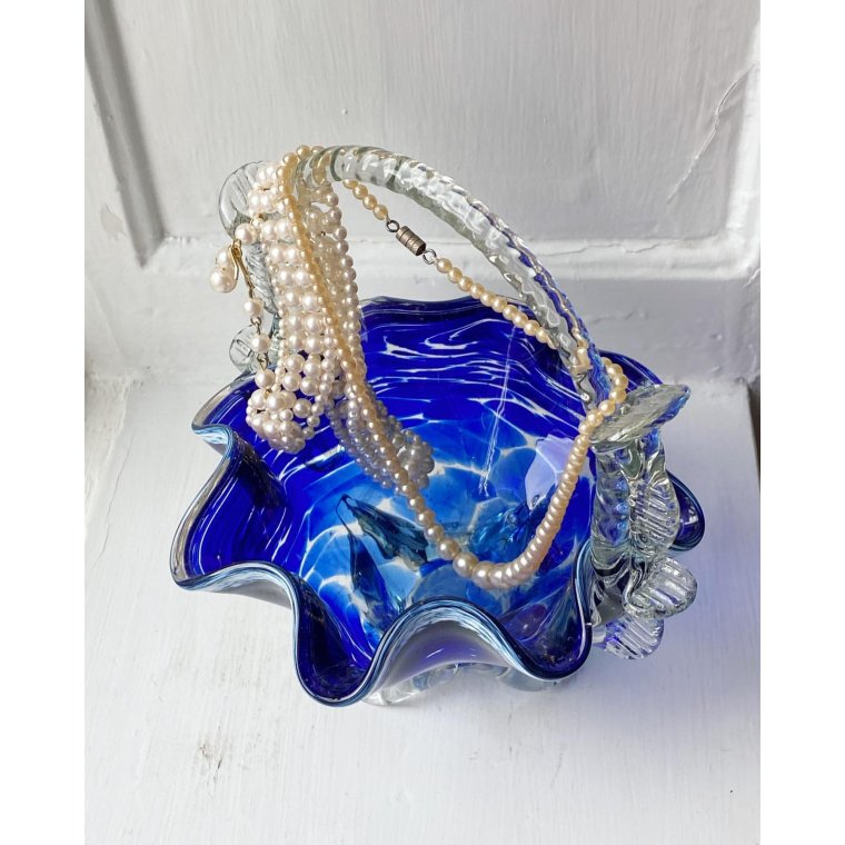 Blue glass basket with clear handle and white edge