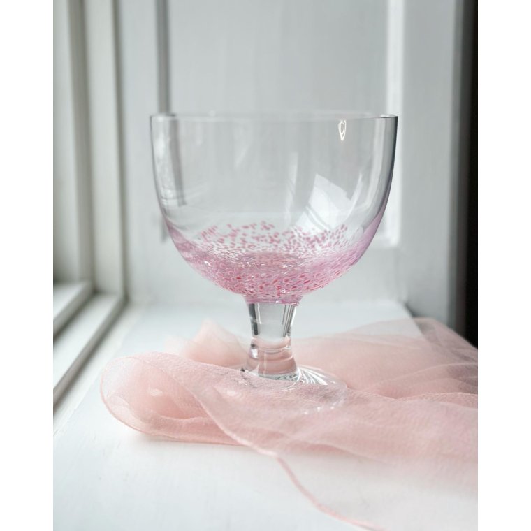 Klar glasopsats med lyserde prikker i bunden, NB