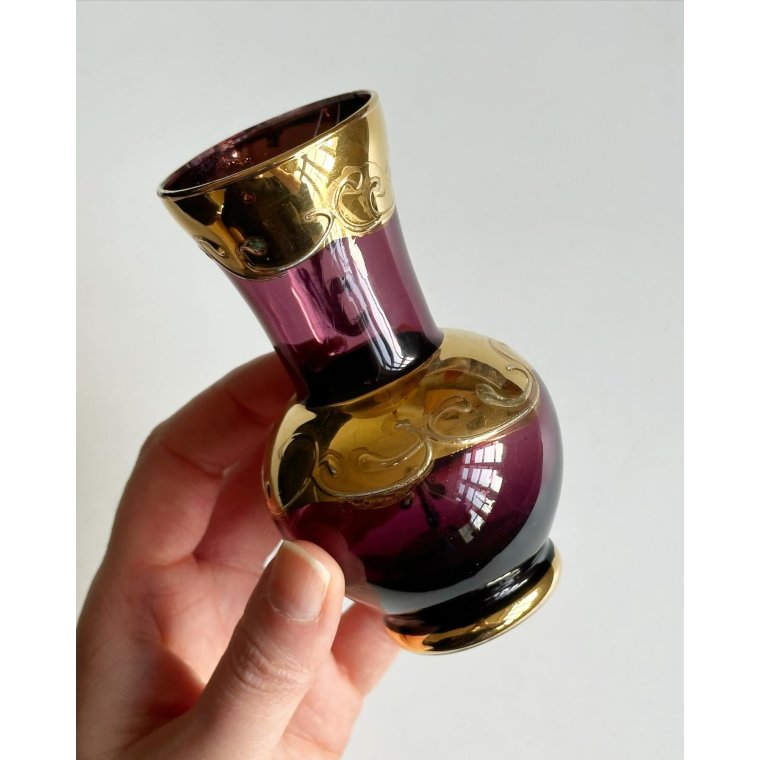 Lilla glas med gulddeko og blomst